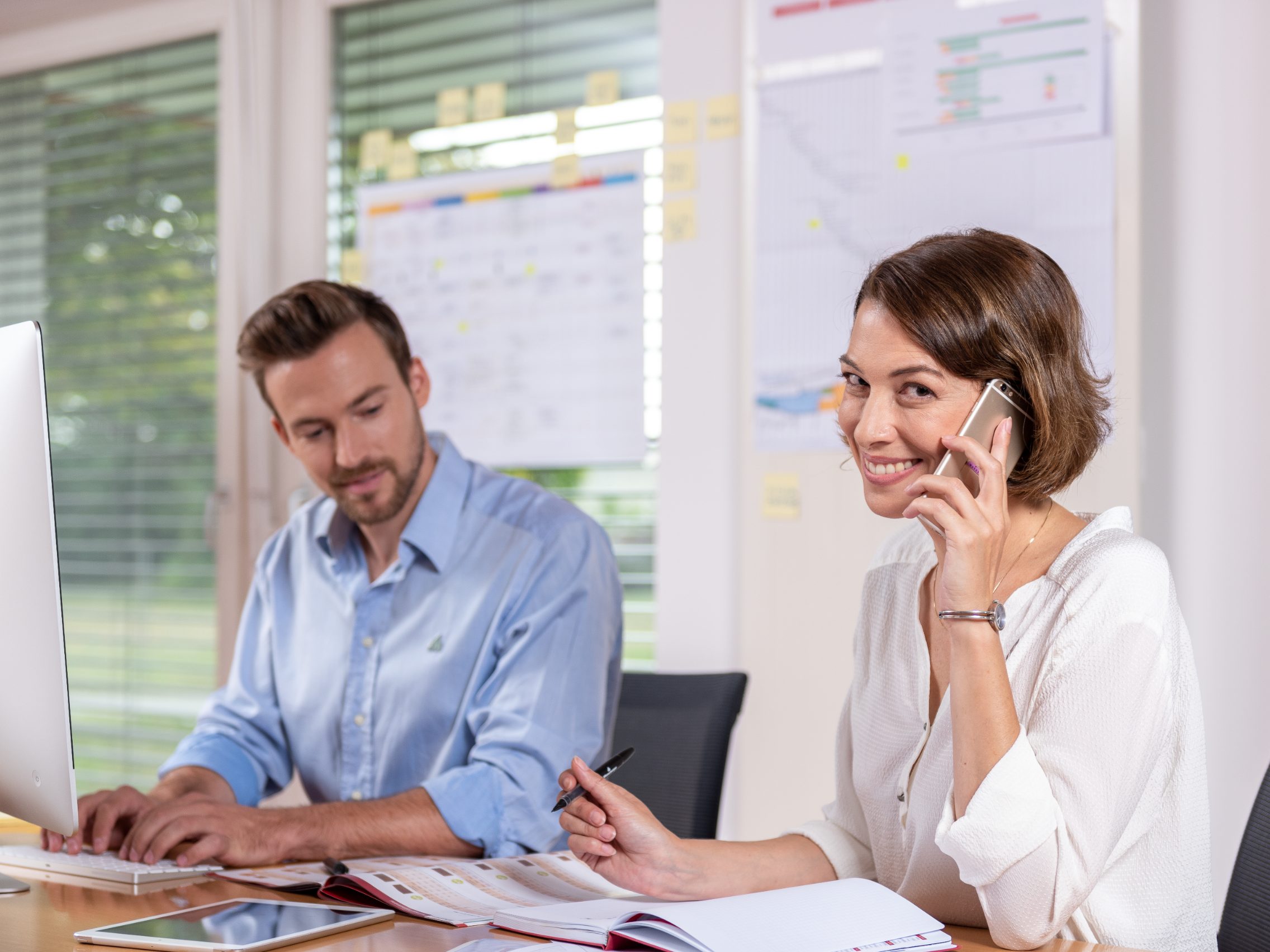 Male and female project manager collaborating in front of computer screen at office