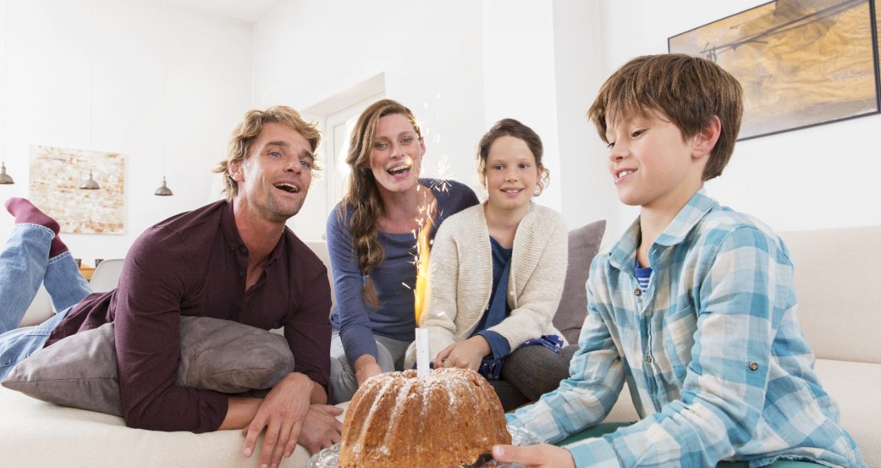 Boy carrying birthday cake with sparkler