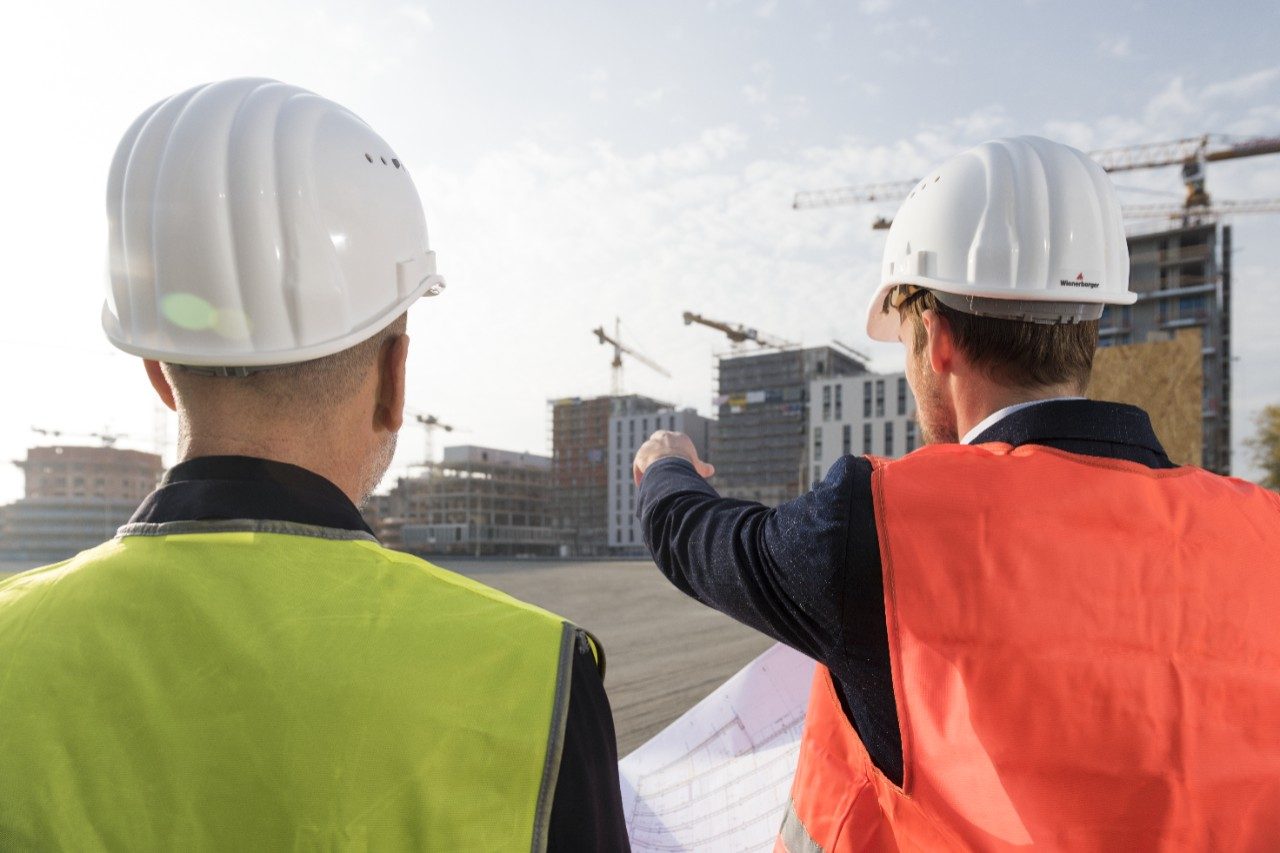 Businessman and architect talking about new building projects at a construction site